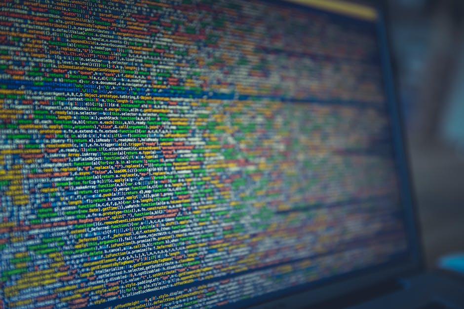 A close-up view of a computer screen displaying colorful lines of programming code in various shades of blue, green, yellow, and red. The code appears complex and densely packed, suggesting active sof